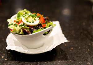 Knackiger Blattsalat mit Tomaten und Ei als Beilage serviert