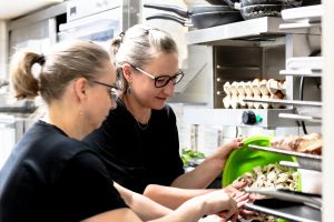 Zwei Mitarbeiterinnen bei der Pilzzubereitung