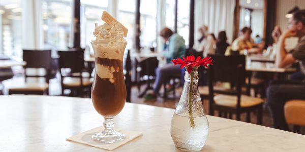 Kühler Eiscafe mit frischer Sahnehaube und knuspriger Waffel