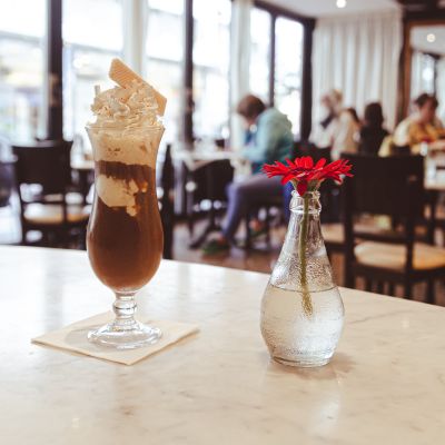 Kühler Eiscafe mit frischer Sahnehaube und knuspriger Waffel