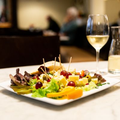 Reichlich belegte Käseplatte mit Oliven und Weintrauben zum Genießen mit Wein und Knabbergebäck