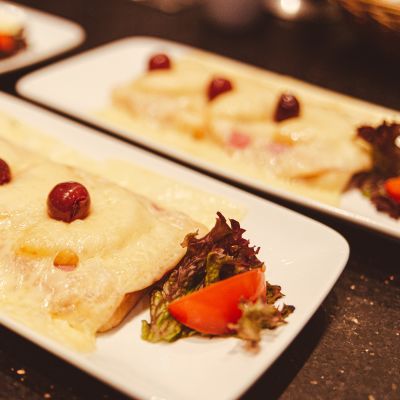 Mit goldbraunem Käse überbackenes Toastbrot, mit Ananas und 3 Kirschen
